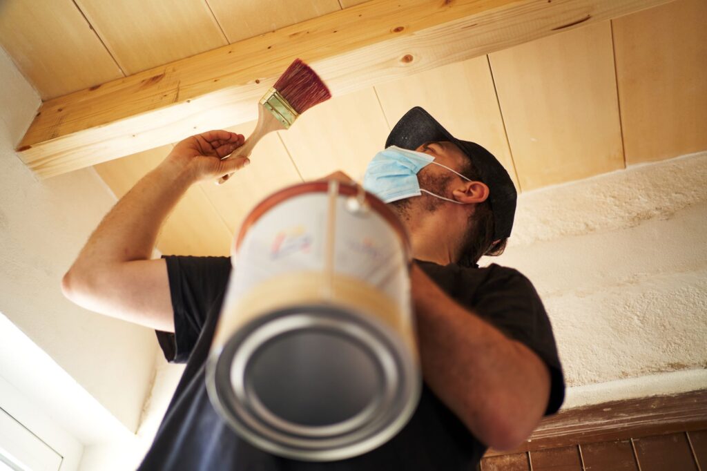 hispanic-man-varnishing-wooden-beam-at-home-2023-11-27-04-49-48-utc.jpg